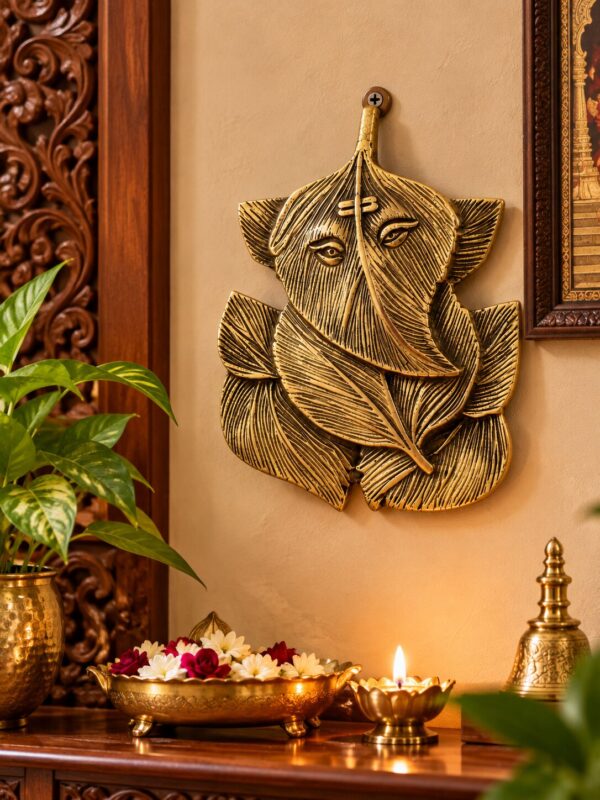 Angled view of brass Leaf Ganapati wall hanging showing its sculpted detailing